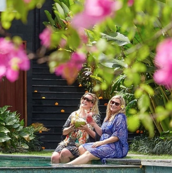 Friends enjoy drinks by the pool Bliss Bali retreat